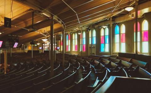 Photo: stained glass windows at the Ryman Auditorium with curved pews in front of them